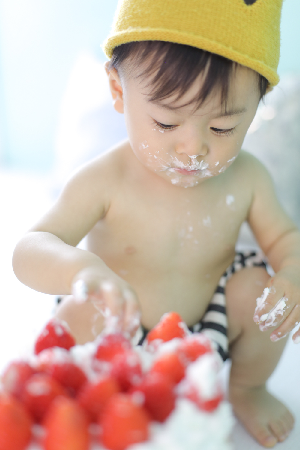 男の子の赤ちゃんがケーキを触っている写真